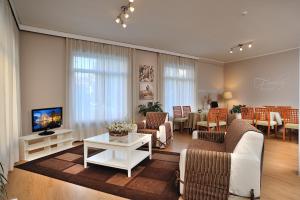 un soggiorno con divano, TV e tavolo di Raffy Family & Bike Hotel a Diano Marina