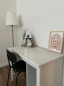 a white desk with a lamp and a chair at Modernes Apartment - Leipzig Alt-West in Leipzig
