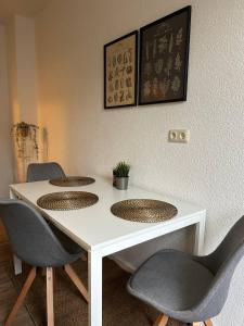 a table with three chairs and a white table at Modernes Apartment - Leipzig Alt-West in Leipzig +3 photos