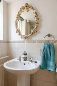 une salle de bain avec un lavabo et un miroir au mur dans l'établissement Cozy One-Bedroom Cottage in Great Tey, à Great Tey