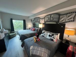 1 dormitorio con 2 camas con animales de peluche en Disneyshuttleking & Queen Be 5 Minutes To Disney, en Orlando 91 fotos más