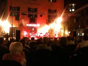 a crowd of people sitting in front of a stage with fires at Casa Nobiallo in Menaggio
