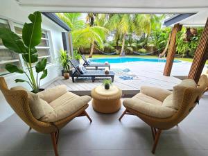 a living room with chairs and a patio with a pool at Sunset Retreat at Heart of Miami with pool in Miami