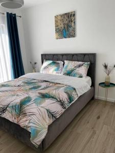 a bedroom with a bed with a bedspread with leaves at Magnifique villa avec jacuzzi in Bourgheim