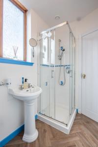 a bathroom with a shower and a sink at Mabels Cottage by the beach in Nairn