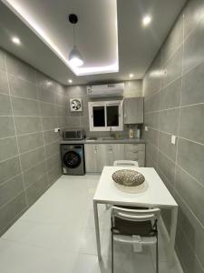 a small kitchen with a white table and chairs at سماء البوادي للشقق المفروشة in Jeddah