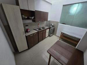 a small kitchen with a sink and a stove at Céntrico departamento en el Piso 1 in Tacna +8 photos