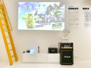 a wall with a poster of a video game at CHENGDU Liaofan Design B&B Houwu Temple Jinli Twin Suite Ximenqiao Street Morogo White Castle HD Projection LOFT Double Floor Bnb High-Quality Housing in Chengdu