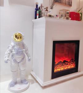 a statue of an astronaut in front of a fireplace at CHENGDU Liaofan Design B&B Houwu Temple Jinli Twin Suite Ximenqiao Street Morogo White Castle HD Projection LOFT Double Floor Bnb High-Quality Housing in Chengdu