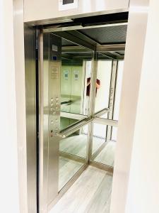a person taking a picture of a glass elevator at APART Caballito II in Buenos Aires