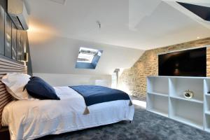 Un dormitorio con una cama grande y un televisor de pantalla plana. en Cocöon Rance, en Plouër-sur-Rance