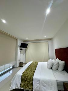 a bedroom with a large white bed in a room at Hotel Ipanema Meridian in Neiva
