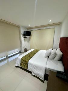 a bedroom with a large white bed and a television at Hotel Ipanema Meridian in Neiva +71 photos
