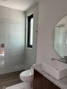 a bathroom with a sink and a toilet and a mirror at Loft nuevo en Zona Romántica 203 in Puerto Vallarta