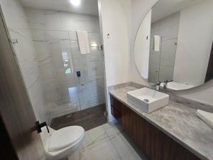 a bathroom with a toilet and a sink and a mirror at Loft nuevo en Zona Romántica 203 in Puerto Vallarta