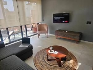 a living room with a couch and a table and a tv at Loft nuevo en Zona Romántica 203 in Puerto Vallarta +32 photos