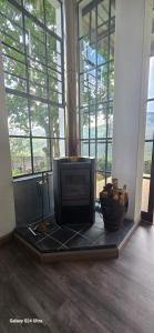 a room with a television on a floor with windows at Villa by Voila in Mbabane
