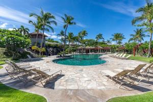 Una piscina tipo resort con tumbonas y palmeras. en Fairways at Mauna Lani 1405 Garden View 3B 2 and half Bath, en Waikoloa