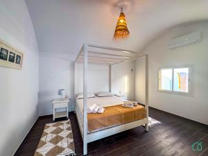 1 dormitorio con cama con dosel en una habitación en Padel Resort: 2bd Apt with panoramic view, en Rafrāf