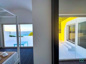 Habitación con balcón y vistas a una casa. en Padel Resort: 2bd Apt with panoramic view, en Rafrāf