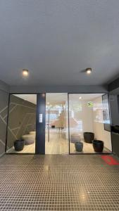 a room with glass doors and a room with a living room at APART Caballito II in Buenos Aires