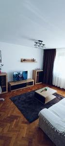 una sala de estar con una cama y una mesa en Apartament ultracentral lux, en Piteşti
