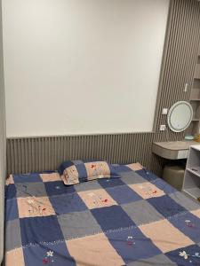 Un dormitorio con una cama con una colcha encima en Masterise Vin, en Phú Thú