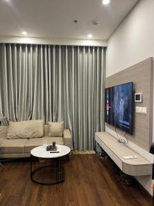 una sala de estar con un sofá y una mesa en Masterise Vin, en Phú Thú