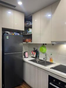 Una cocina con un refrigerador negro y un fregadero. en Masterise Vin, en Phú Thú 5 fotos más