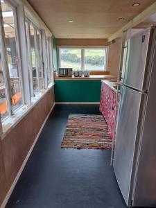 a kitchen with a refrigerator and a counter with windows at The Woolshed, Papa Aroha, Coromandel in Moturua Island +21 photos