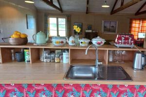 a kitchen with a sink and a counter with dishes at The Woolshed, Papa Aroha, Coromandel in Moturua Island