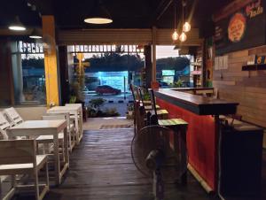 a restaurant with a bar and tables and chairs at Non La Mer Hostel - Bed & Yoga in Ko Lanta