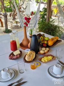 a white table with food on a table with a table cloth at Casa Mais Amor in Atins