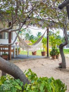 a hammock hanging from a tree in a yard at Casa Mais Amor in Atins