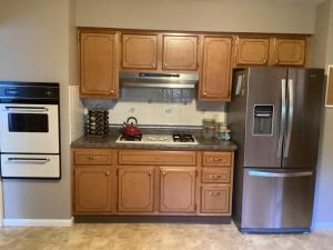 a kitchen with wooden cabinets and stainless steel appliances at Family friendly spacious with jacuzzi & fireplace! in Dubuque +10 photos
