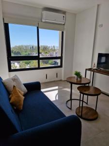 サンフアンにあるDepto Alem y Central RFの青いソファと大きな窓のあるリビングルーム