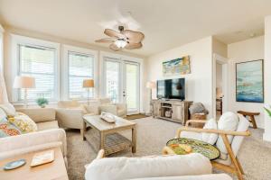 a living room with white furniture and a flat screen tv at Open Airy Beautiful - Ocean AND Bay Views! in Galveston