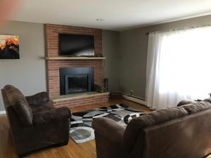 a living room with a couch and a fireplace at Family friendly spacious with jacuzzi & fireplace! in Dubuque