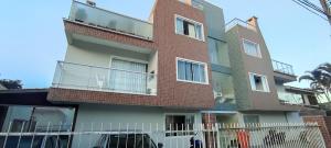 a brick building with a fence in front of it at APARTAMENTO DE PRAIA in Florianópolis