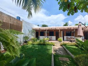a house with a garden in front of it at 5R Tourist Inn & Restaurant in Pooc