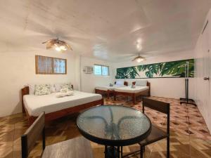 a room with two beds and a table in it at 5R Tourist Inn & Restaurant in Pooc