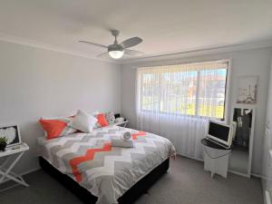a bedroom with a large bed and a window at Rocky in South West Rocks