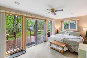 a bedroom with a bed and sliding glass doors at Lakefront with Lots of Light and Private Dock Access in Ferndale