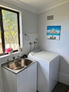 a small kitchen with a sink and a window at Rocky in South West Rocks +7 photos