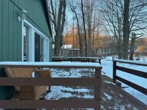 a snow covered bench next to a green building at Lakefront with Lots of Light and Private Dock Access in Ferndale