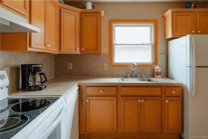 a kitchen with wooden cabinets and a sink and a window at Lakefront with Lots of Light and Private Dock Access in Ferndale