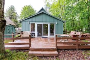 a green shed with a wooden deck and chairs at Lakefront with Lots of Light and Private Dock Access in Ferndale
