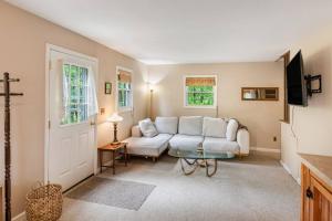 a living room with a white couch and a tv at Lakefront with Lots of Light and Private Dock Access in Ferndale