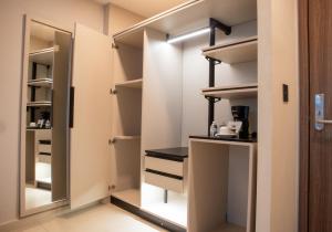 a walk in closet with white cabinets and a mirror at Grand Hotel&Casino Vía Dorada in Pachuca de Soto