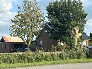 a house with a car parked in front of it at vakantiehuisje DE WEELEN met Jacuzzi Huwelijks topkeuze! in Lutjebroek